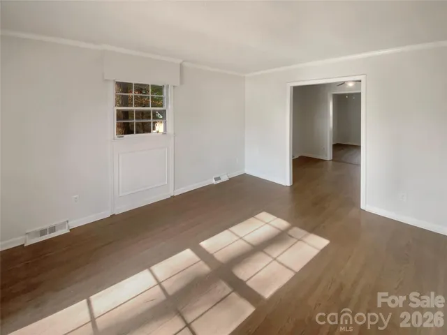 wooden floor in an empty room with a window