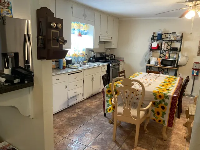 a kitchen with a table chairs refrigerator and microwave