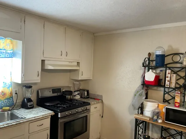 a kitchen with granite countertop a stove and a sink