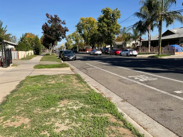 a view of street with cars parked on the roadside