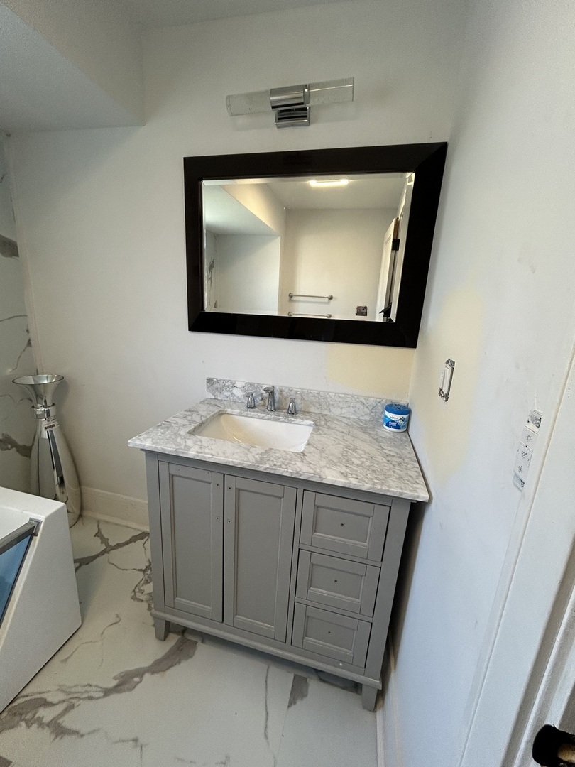 5915 West Iowa Street Chicago, IL 60651 - Photo 14 of 35 a bathroom with a granite countertop sink a mirror and bathtub