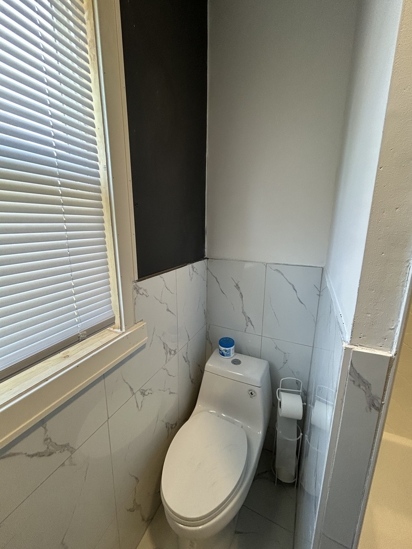 5915 West Iowa Street Chicago, IL 60651 - Photo 5 of 35 a white toilet sitting next to a window