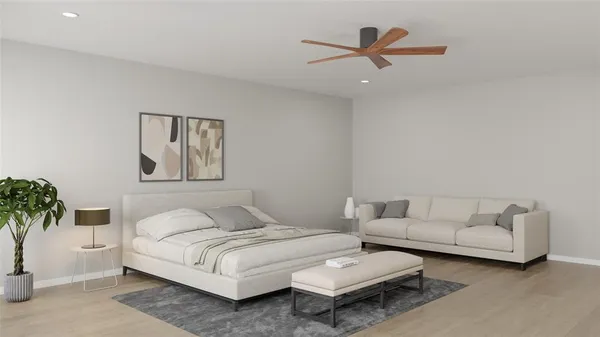 a bedroom with a bed couches and a potted plant