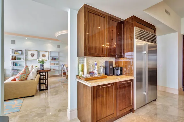 a kitchen with stainless steel appliances kitchen island granite countertop a table chairs and a refrigerator