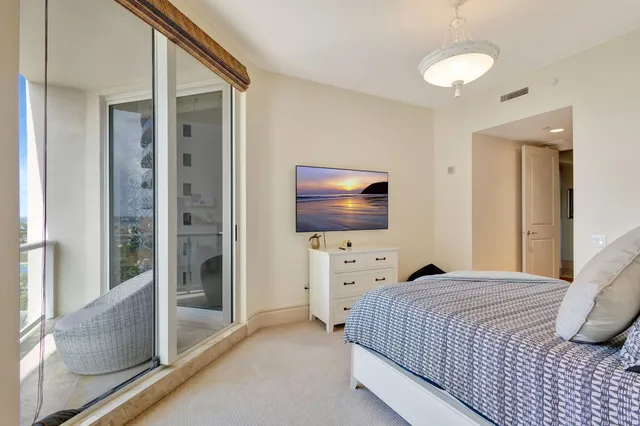 a bedroom with a bed lamps and wooden floor