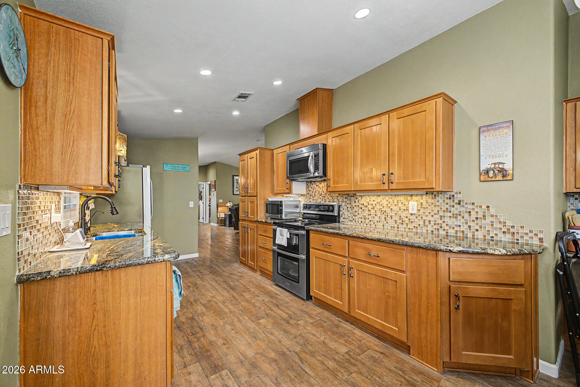 2550 South Ellsworth Road, Unit 611 Mesa, AZ 85209 - Photo 18 of 34 a kitchen with stainless steel appliances granite countertop a stove a sink and a refrigerator