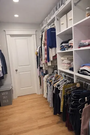 a view of walk in closet with clothes and shoes