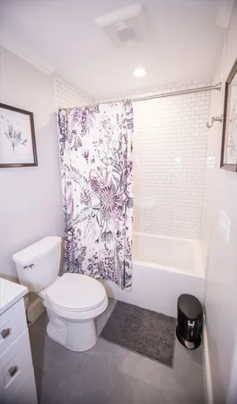 a white toilet sitting next to a bath tub