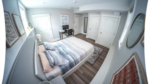 a bedroom with a bed with mirror and furniture