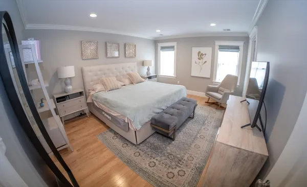 a spacious bedroom with a bed and a large mirror