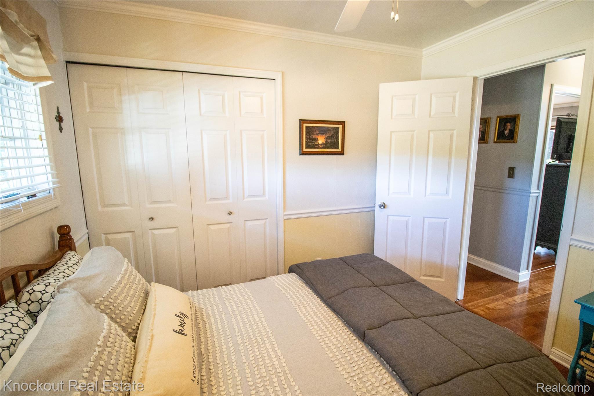 14720 Lincoln Road Chesaning, MI 48616 - Photo 24 of 60 Bi-fold panel closet doors, ceiling fan light fixture, wood-finish flooring, paneled interior door, and crown molding