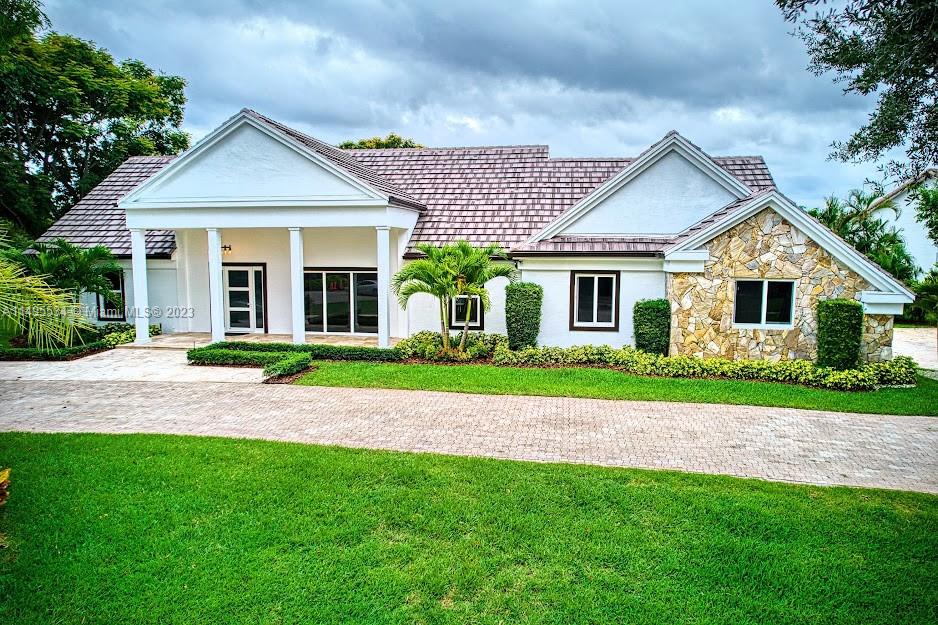 3010 Equestrian Drive Boca Raton, FL 33434 - Photo 1 of 53 a front view of a house with a yard and garage