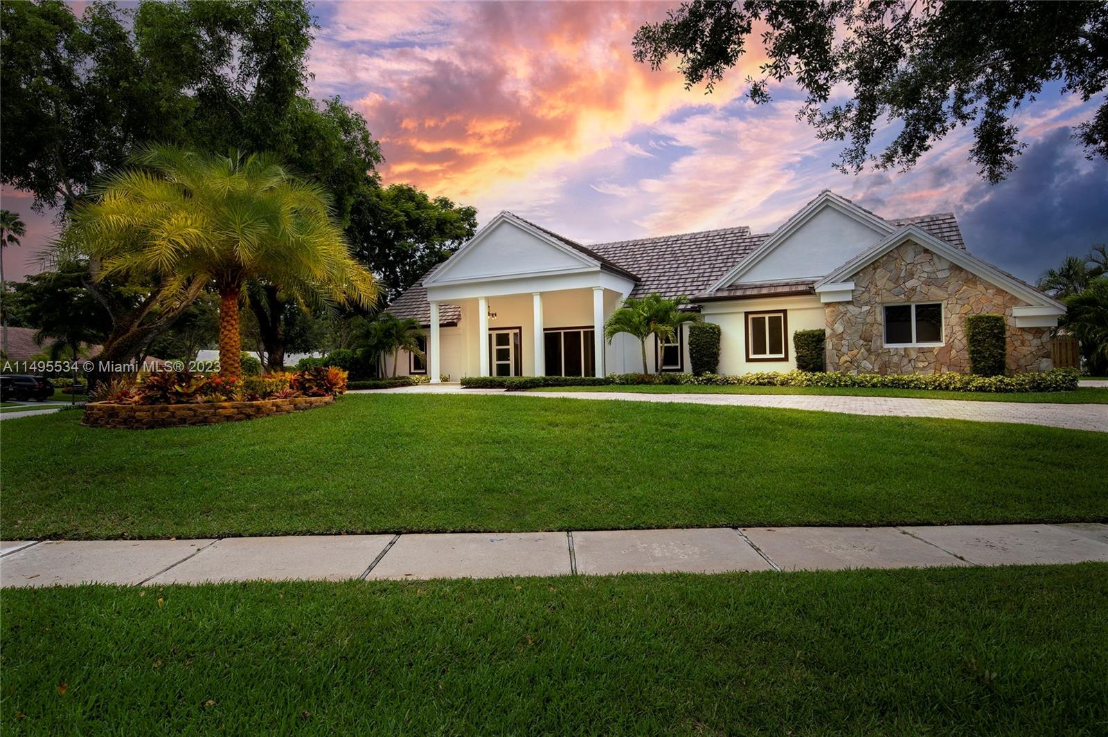 3010 Equestrian Drive Boca Raton, FL 33434 - Photo 2 of 53 a front view of a house with a garden and trees