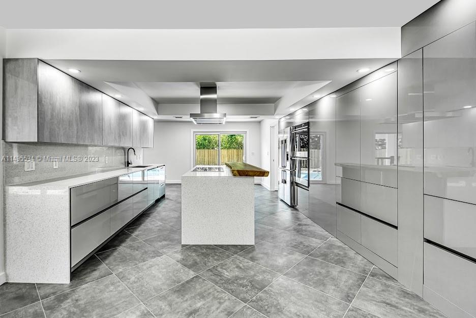 3010 Equestrian Drive Boca Raton, FL 33434 - Photo 21 of 53 a large white kitchen with a large window and stainless steel appliances