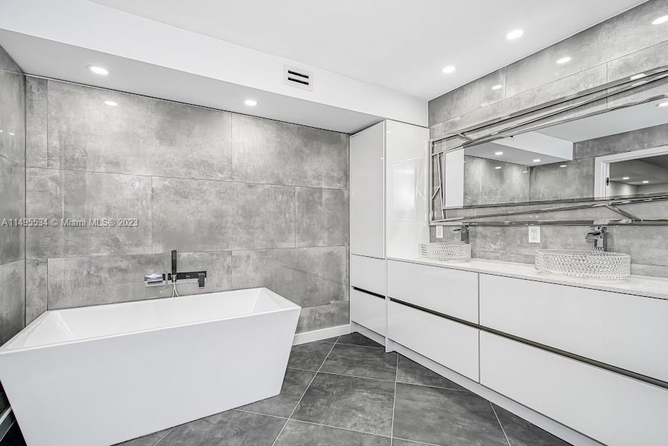 3010 Equestrian Drive Boca Raton, FL 33434 - Photo 32 of 53 a bathroom with a sink a mirror and a bathtub