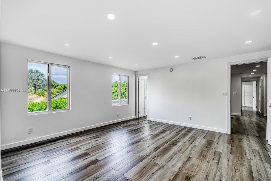 3010 Equestrian Drive Boca Raton, FL 33434 - Photo 39 of 53 an empty room with wooden floor and windows