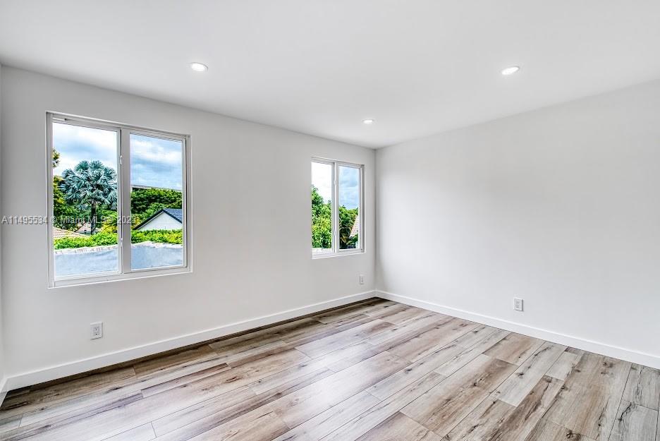 3010 Equestrian Drive Boca Raton, FL 33434 - Photo 46 of 53 an empty room with wooden floor and windows