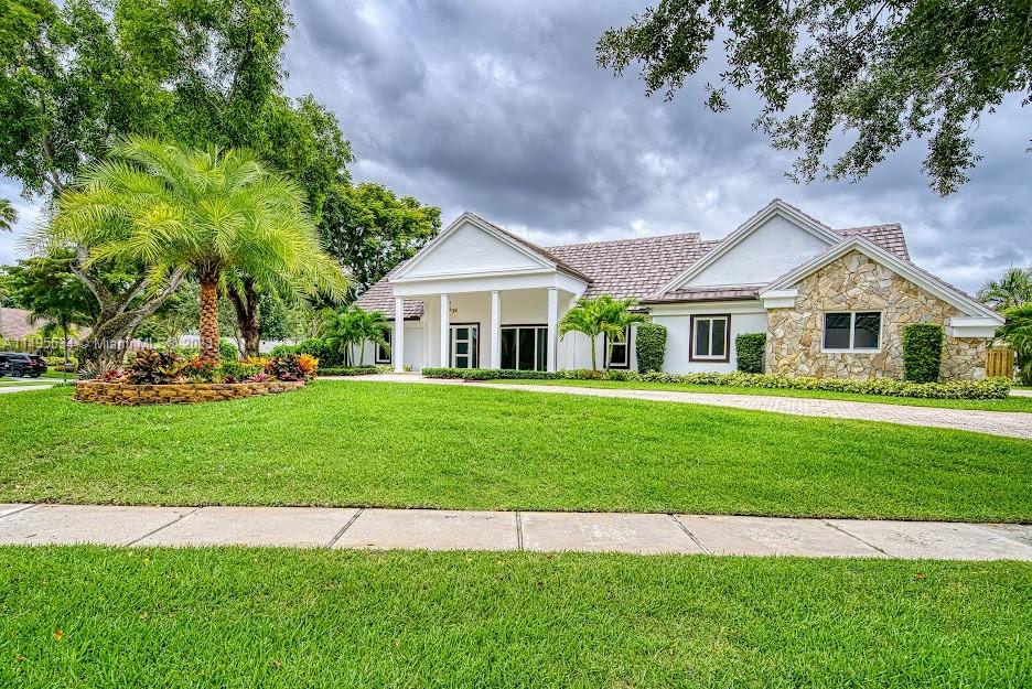 3010 Equestrian Drive Boca Raton, FL 33434 - Photo 9 of 53 a front view of a house with a garden