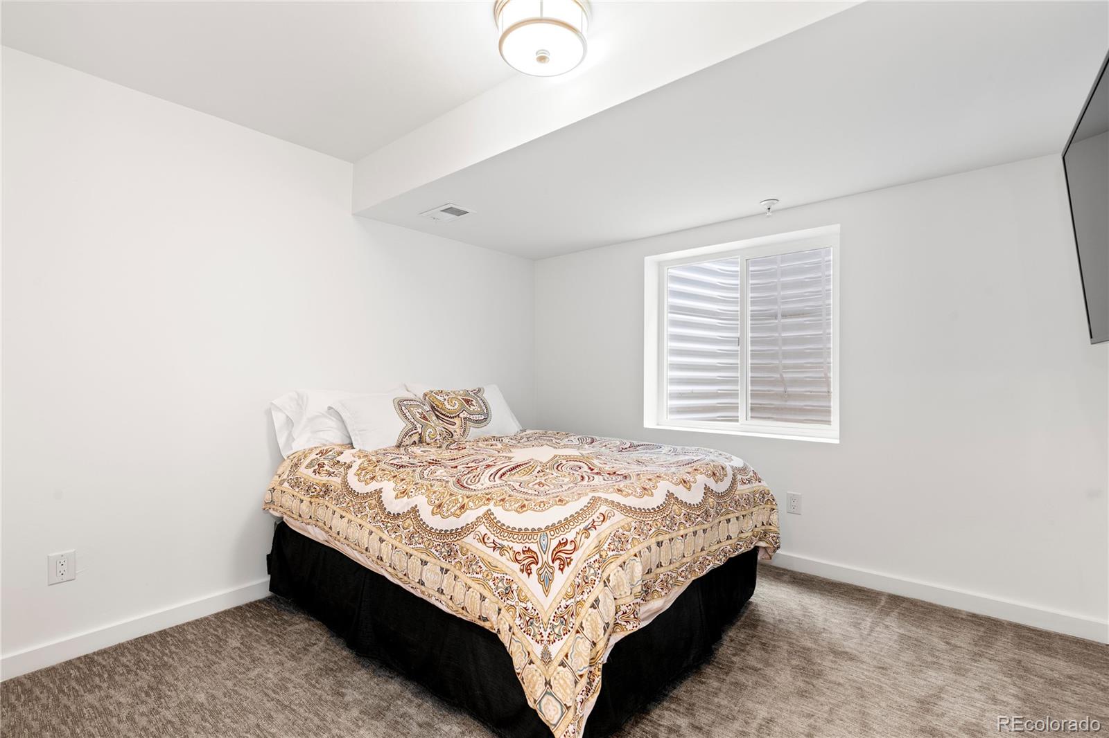 5327 Raleigh Street Denver, CO 80212 - Photo 33 of 40 a bed sitting in a bedroom next to a window