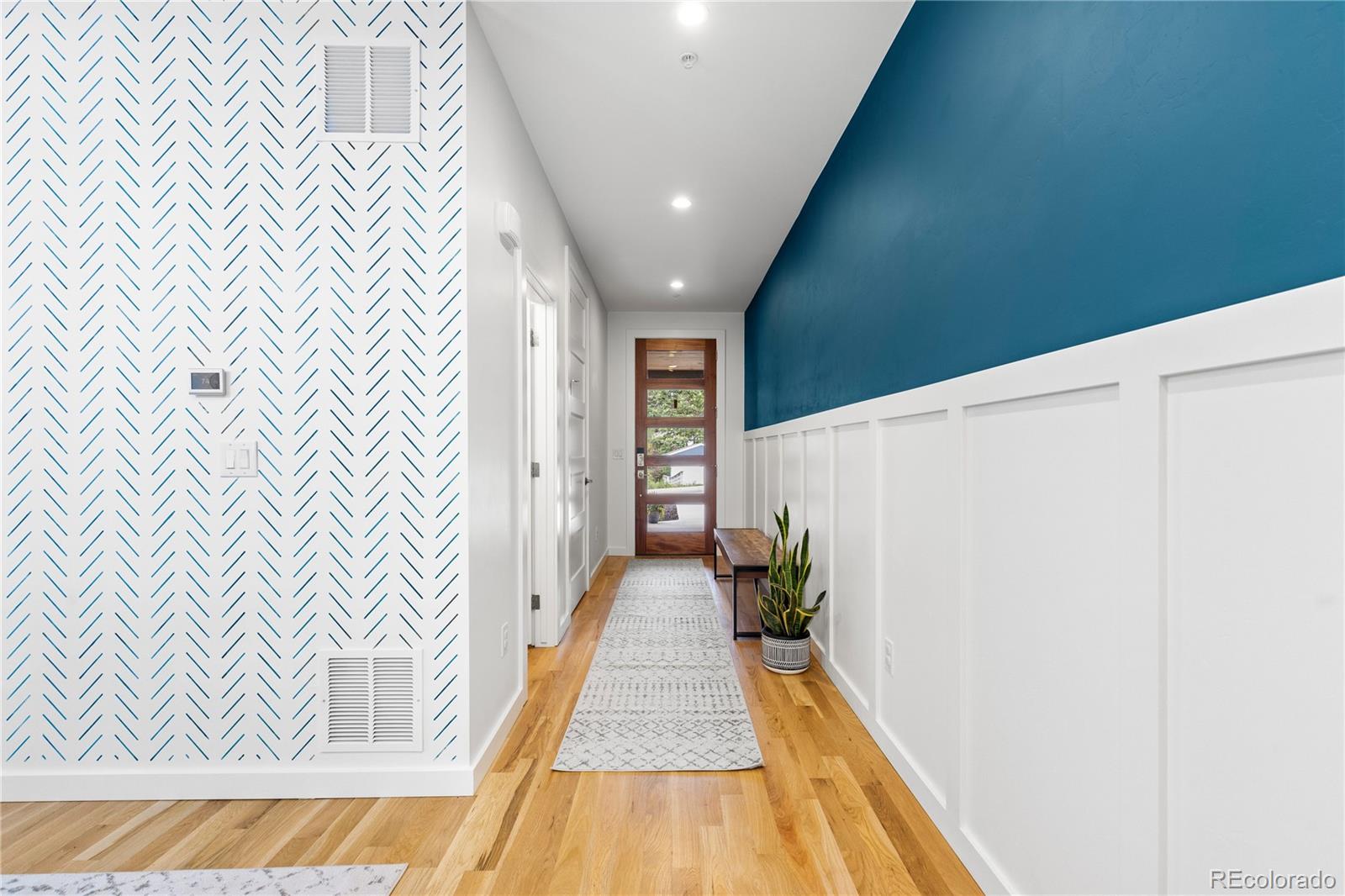 5327 Raleigh Street Denver, CO 80212 - Photo 4 of 40 a view of a hallway with wooden floor and staircase