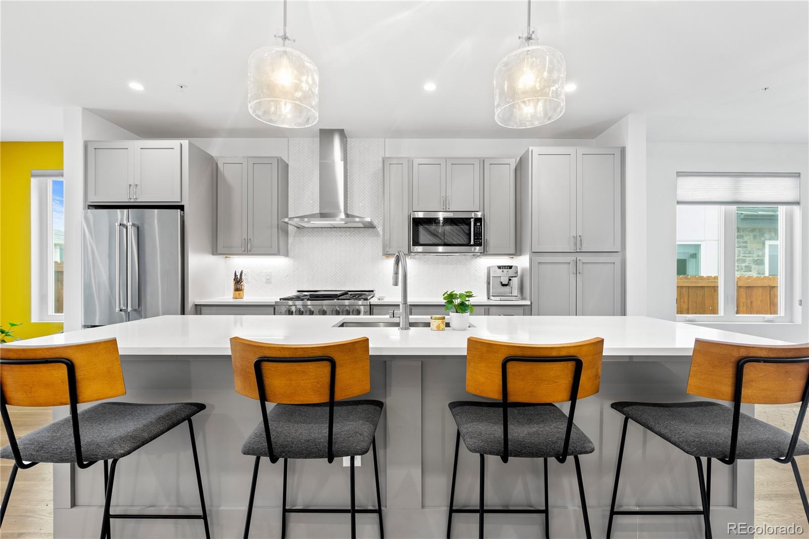 5327 Raleigh Street Denver, CO 80212 - Photo 9 of 40 a kitchen with stainless steel appliances granite countertop a stove a sink dishwasher a refrigerator with white cabinets and wooden floor