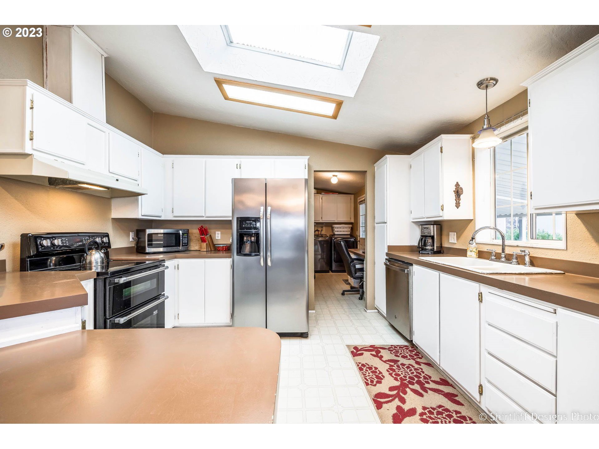 1699 North Terry Street, Unit 164 Eugene, OR 97402 - Photo 12 of 31 a large kitchen with a large counter top appliances and cabinets