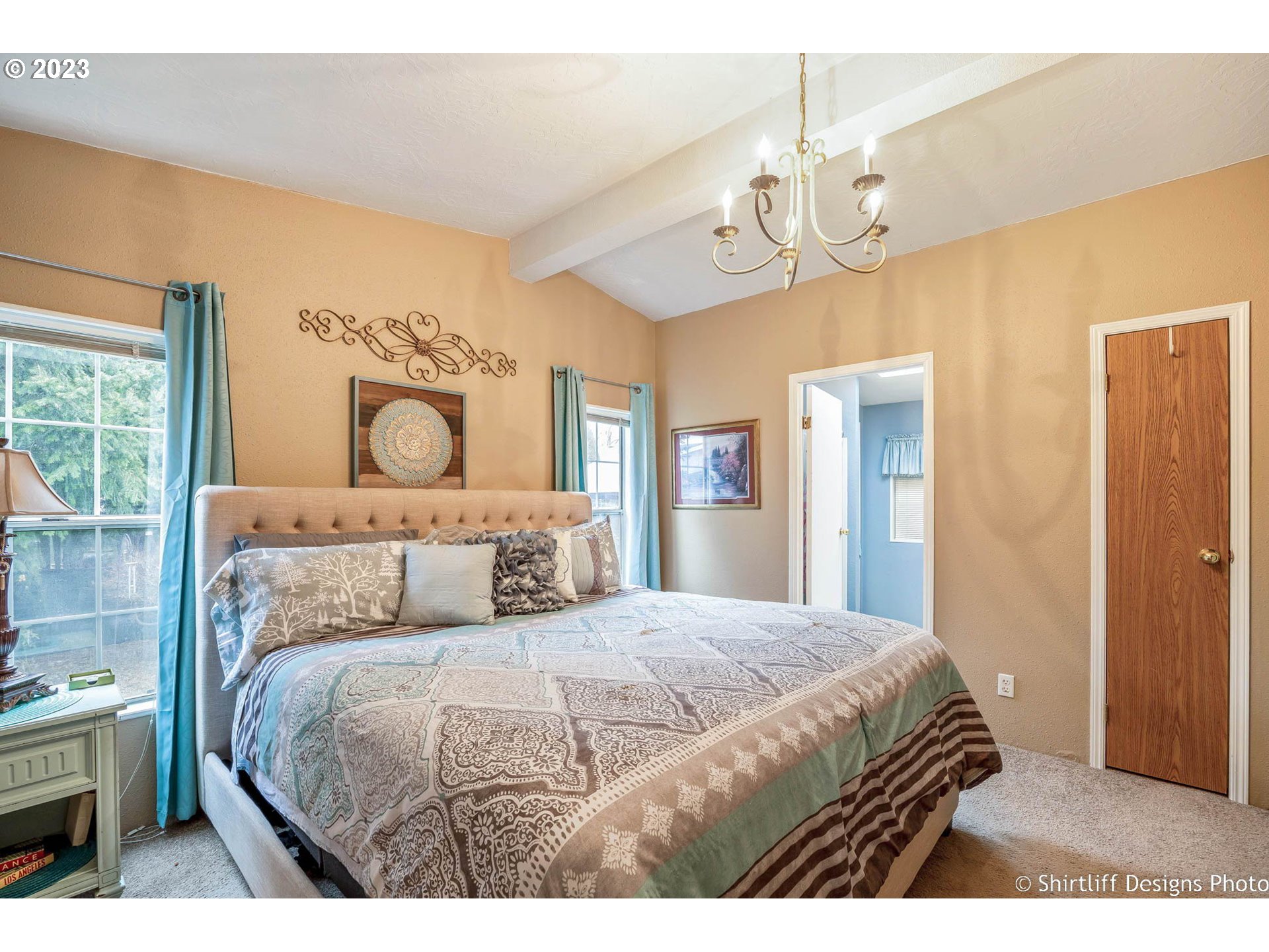 1699 North Terry Street, Unit 164 Eugene, OR 97402 - Photo 22 of 31 a bedroom with a large bed and a chandelier