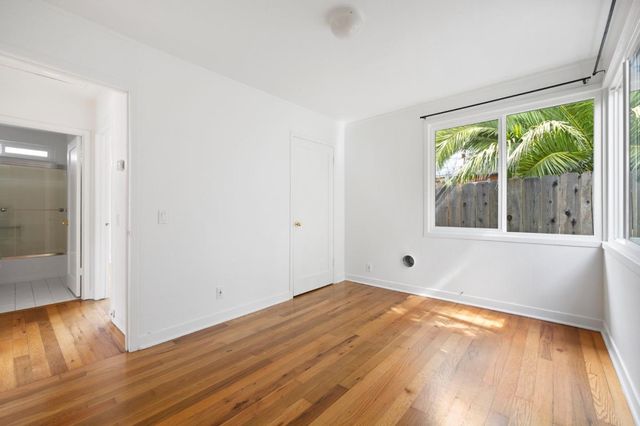 a view of a room with wooden floor and window