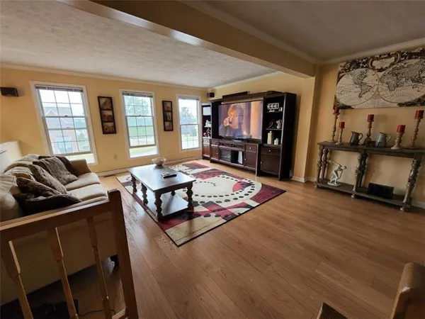 a living room with furniture flat screen tv and a large window