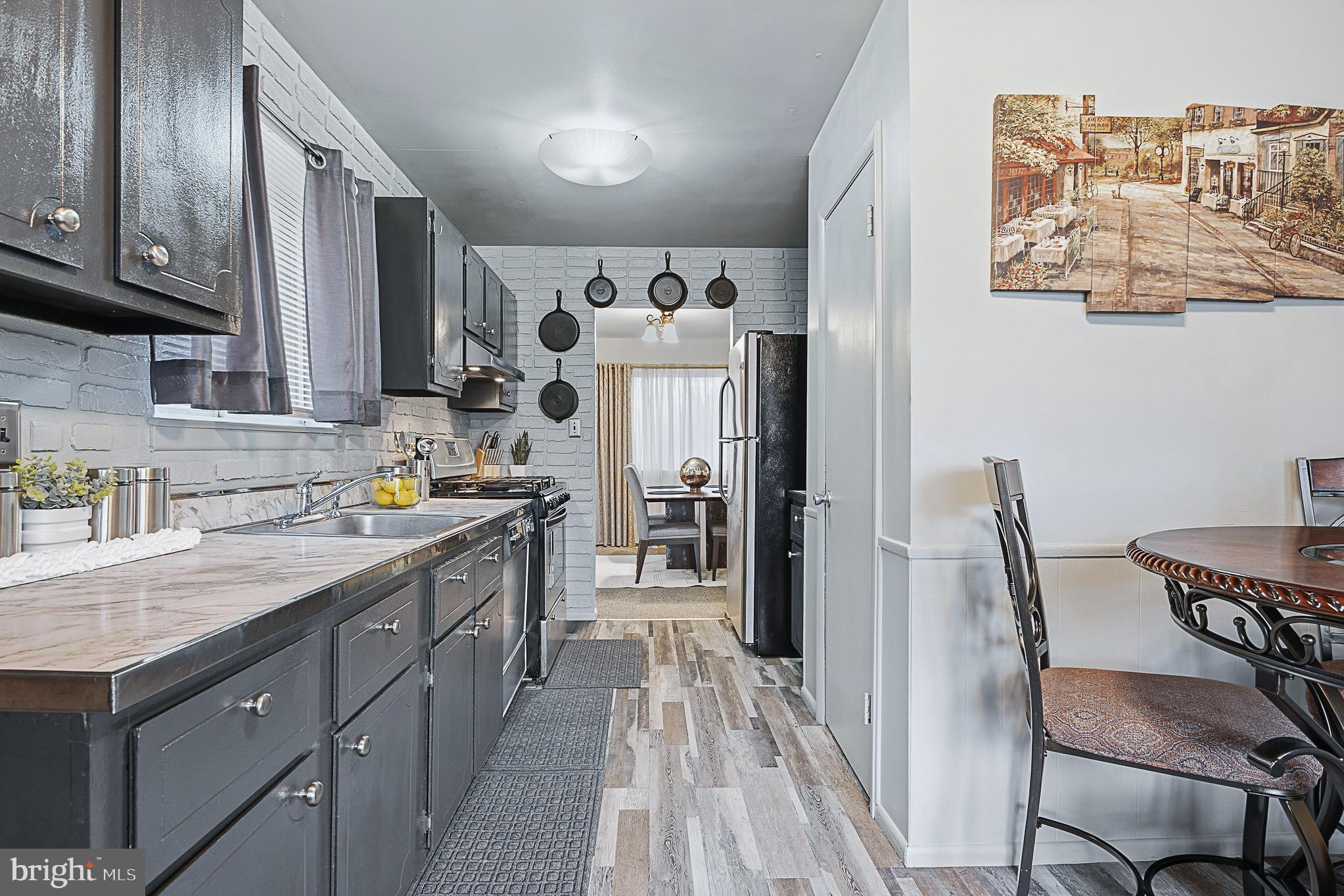 4542 Kinmount Road Lanham, MD 20706 - Photo 26 of 70 a kitchen with stainless steel appliances granite countertop a refrigerator a sink dishwasher and wooden cabinets with wooden floor