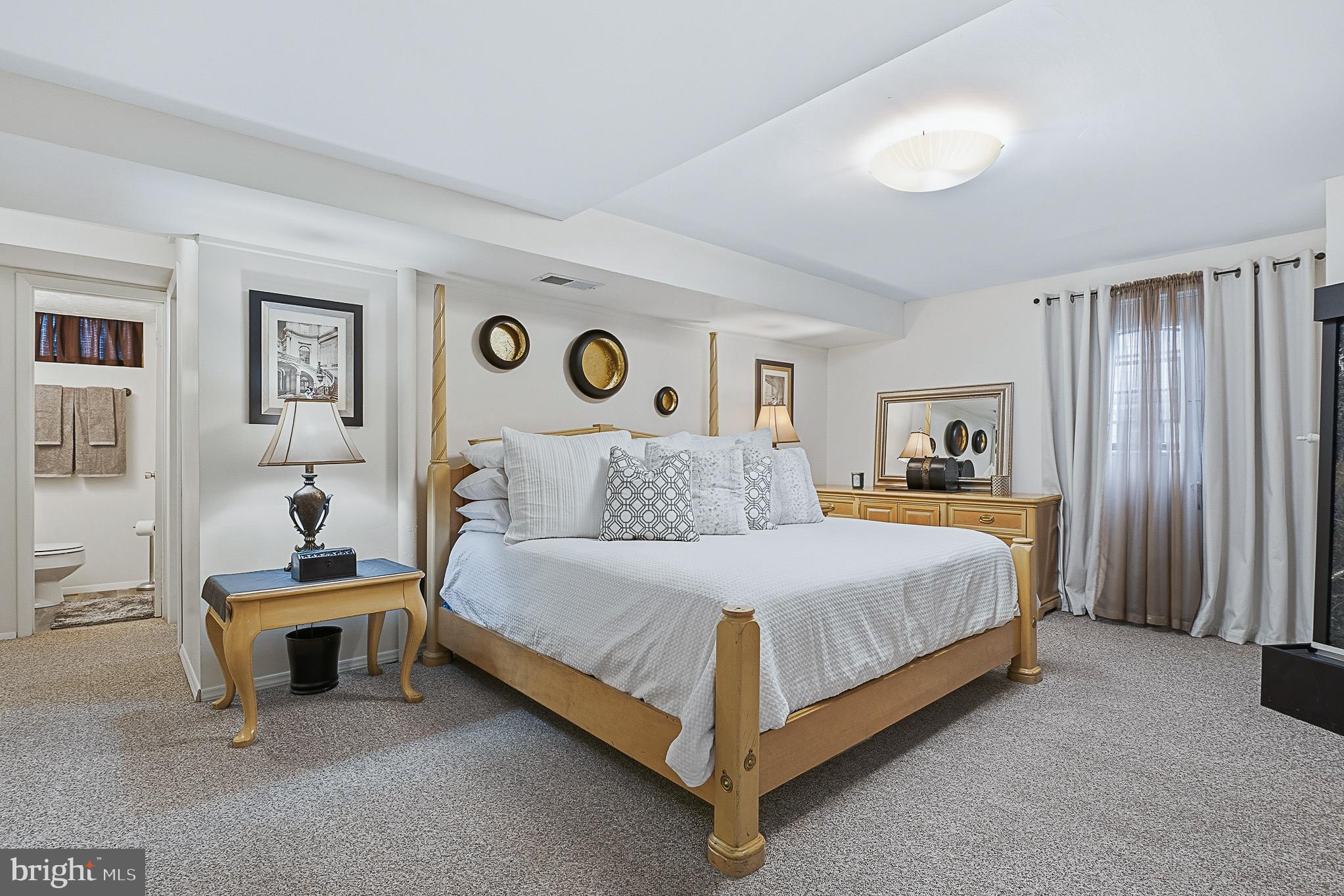 4542 Kinmount Road Lanham, MD 20706 - Photo 55 of 70 a bedroom with a bed lamp and paintings on the wall