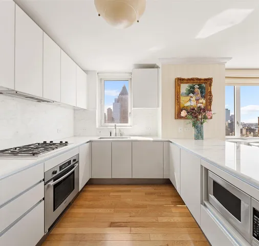 a kitchen with granite countertop white cabinets and white appliances