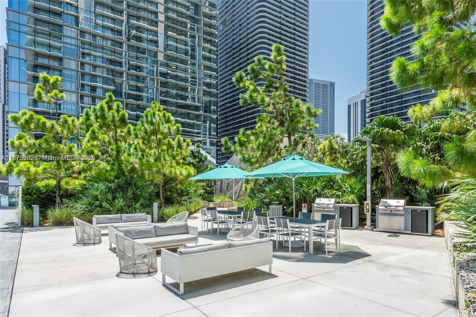 88 Southwest 7th Street, Unit 2204 Miami, FL 33130 - Photo 43 of 58 a view of a patio with plants and chairs under an umbrella