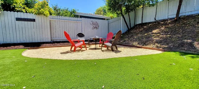 a view of a backyard with potted plants and wooden fence