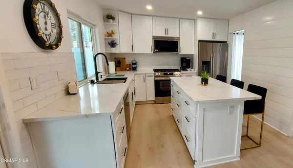 a kitchen with a sink a stove top oven and refrigerator