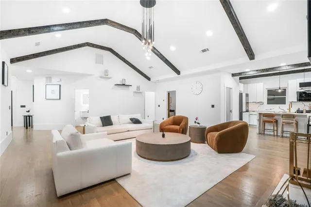a kitchen with stainless steel appliances a dining table chairs stove and cabinets
