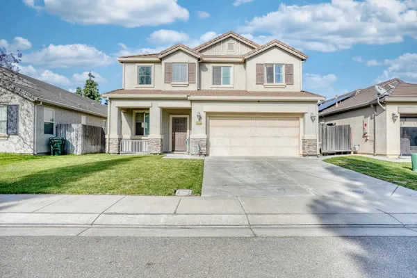 a front view of a house with a yard and garage
