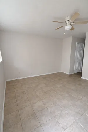 an empty room with a chandelier fan