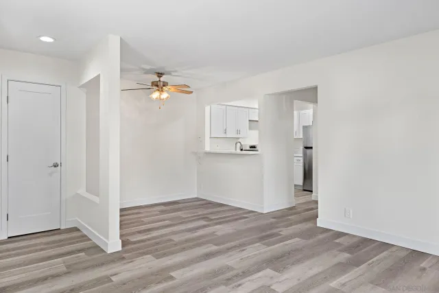 a view of a room with wooden floor and a ceiling fan