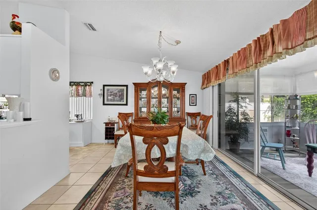 a dining room with wooden floor a chandelier a wooden table and chairs