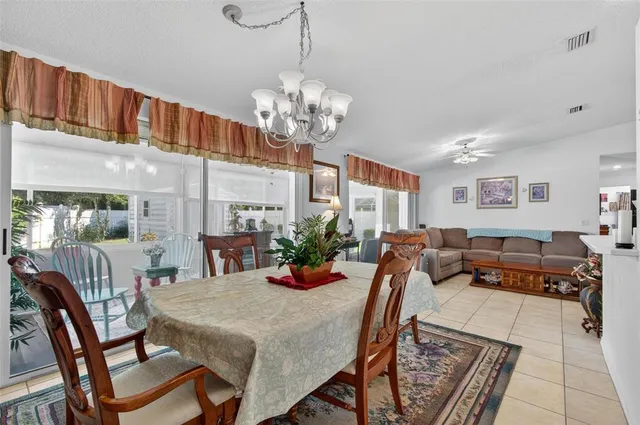 a view of a dining room with furniture a chandelier and wooden floor