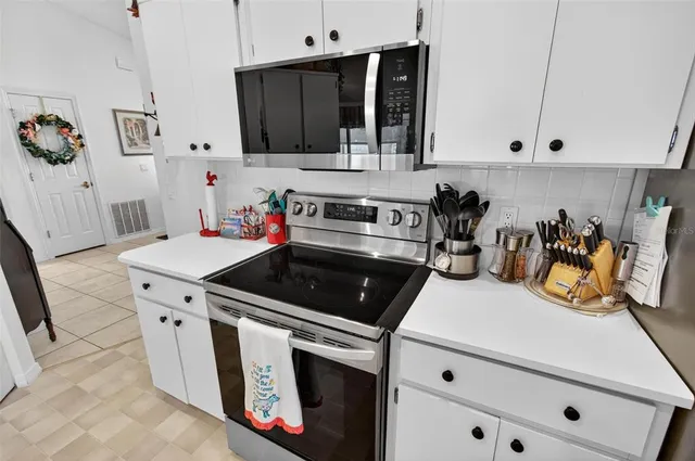 a kitchen with granite countertop a sink a stove and cabinets