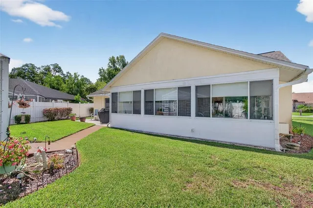 a view of a house with a yard and potted plants