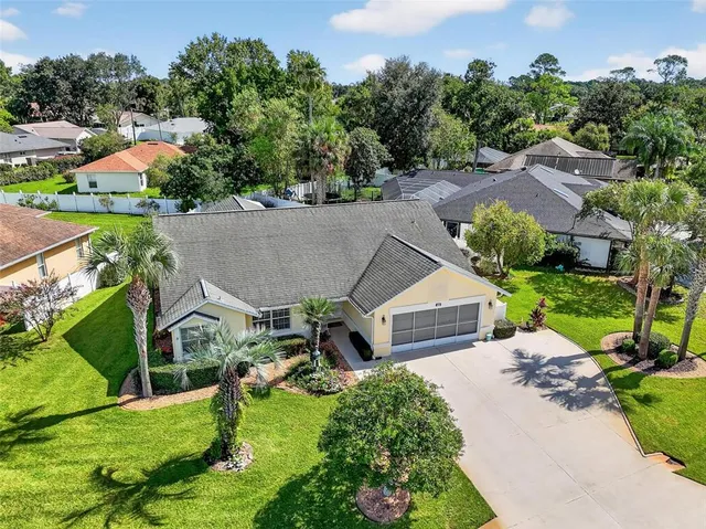 an aerial view of a house with yard green space and lake view