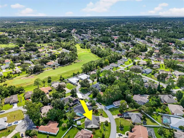 an aerial view of residential houses with outdoor space and trees