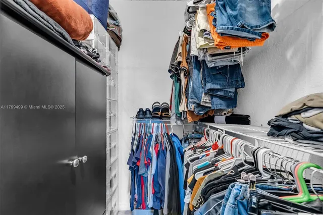 a view of walk in closet with clothes