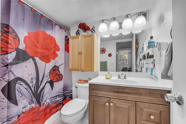 a bathroom with a sink vanity mirror and toilet