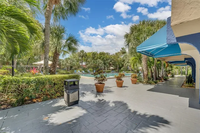 a view of a patio with couches and table and chairs under an umbrella