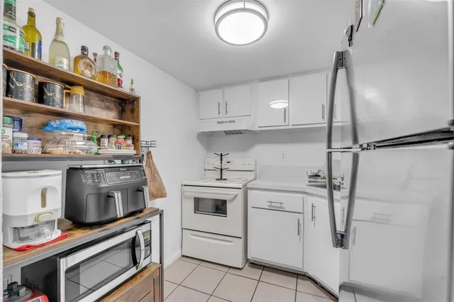 a kitchen with stainless steel appliances a stove a chimney and a cabinets
