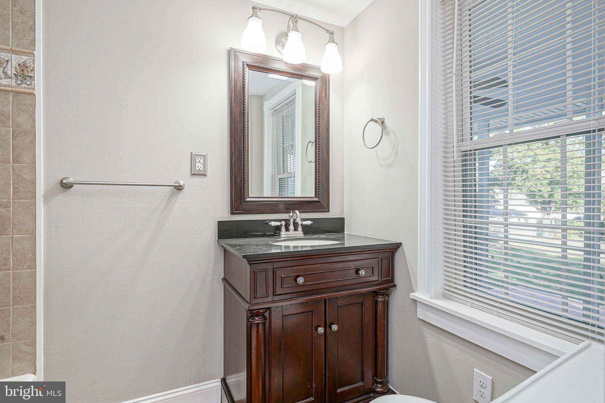 53 Branch Street Medford, NJ 08055 - Photo 20 of 41 a bathroom with a granite countertop sink a mirror and a window